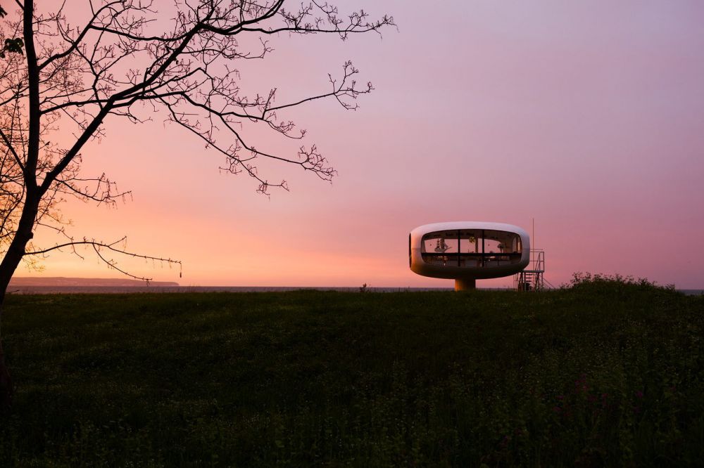 Ufo von Ulrich Müther 
Binz Rügen
Schlüsselwörter: Architektur Moderne futuristisch schwebend geschwungen Betonschalenbau rund weich transparent Sehenswürdigkeit Ufo Feuer Himmel orange gelb Sonnenuntergang Farben Glas Beton Ostsee Ostseebad Atmosphäre Licht leuchten Abend abends menschenleer Ulrich Mü